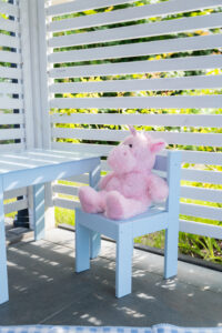 Różowa zabawka na niebieskim krześle.