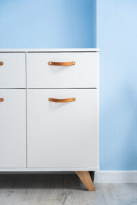 Biały mebel z brązowymi uchwytami