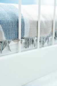 Białe łóżko z kolorowym kocem